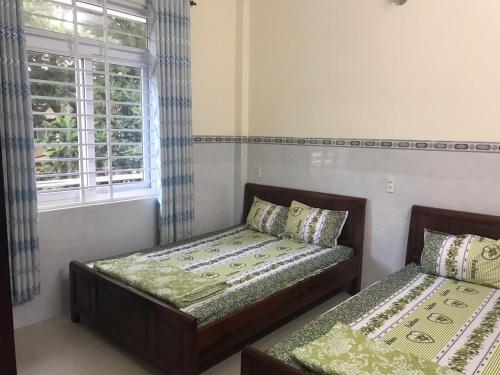 a bedroom with two beds and a window at Motel Liên Anh in Vung Tau