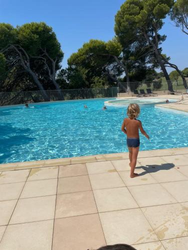 une petite fille debout en face d'une piscine dans l'établissement Le Paradis vert, à Saumane-de-Vaucluse