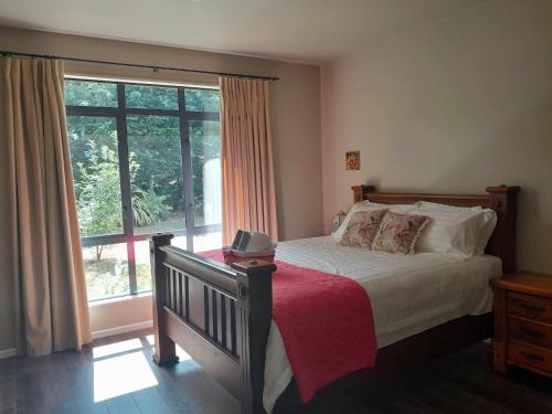 a bedroom with a bed and a large window at Springfield Retreat in Springfield