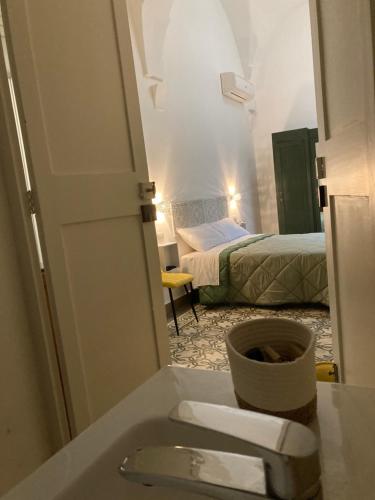 a bathroom with a toilet and a room with two beds at B&B Antica Dimora dell'Angelo in Nardò