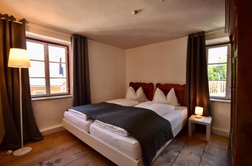 een slaapkamer met een groot bed en 2 ramen bij Sommerfrische Tschengls in Lasa