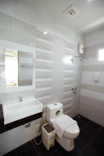 a white bathroom with a toilet and a sink at Ioon Resort ไออุ่นรีสอร์ท in Sara Buri