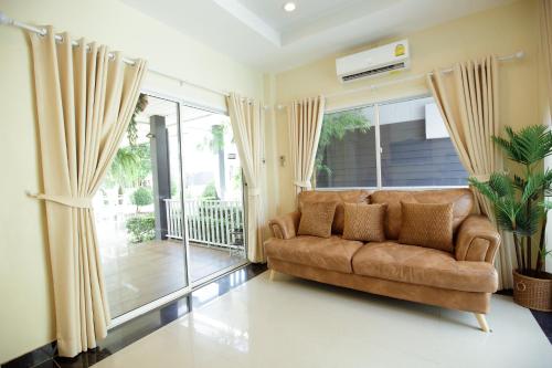 a living room with a couch and a large window at Ioon Resort ไออุ่นรีสอร์ท in Sara Buri