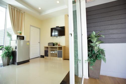a living room with a refrigerator and a tv at Ioon Resort ไออุ่นรีสอร์ท in Sara Buri