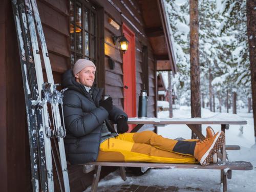 a man sitting at a picnic table in the snow at Sjodalen Hyttetun og Camping in Stuttgongfossen