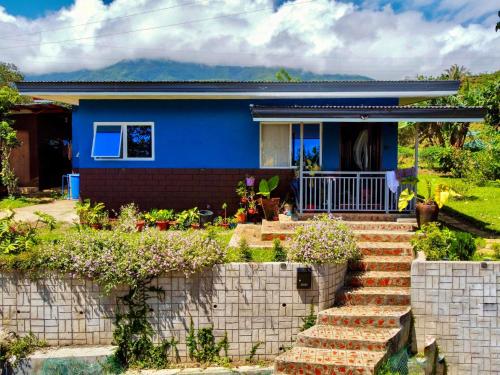 uma casa azul com escadas em frente em Bushis Crib Staycation Farmhouse em Panubigan