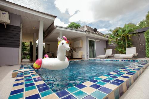 a pool with a unicorn inflatable duck in the water at Ioon Resort ไออุ่นรีสอร์ท in Sara Buri