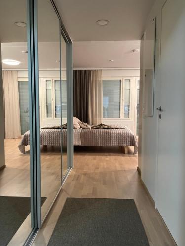 - une chambre avec un lit et une porte coulissante en verre dans l'établissement Studio VIP - close to airport and Tikkurila train station, à Vantaa
