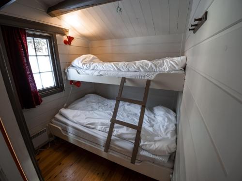 a small room with two bunk beds and a window at Sjodalen Hyttetun og Camping in Stuttgongfossen
