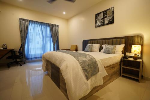 a bedroom with a large bed and a window at DrizzleDrop Inn Chennai in Chennai