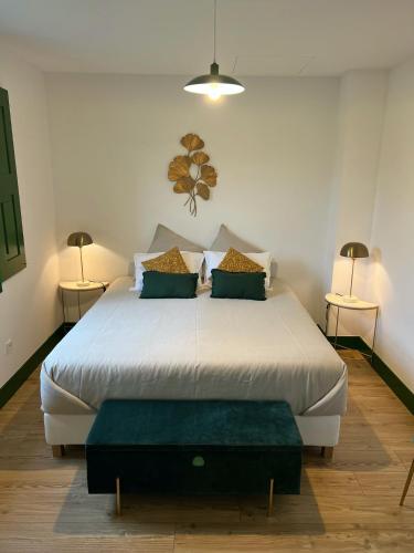 a bedroom with a large white bed with two lamps at Catrinandes - Retreat Center in Tondela