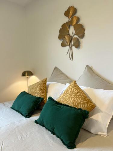 a bed with green and white pillows on it at Catrinandes - Retreat Center in Tondela