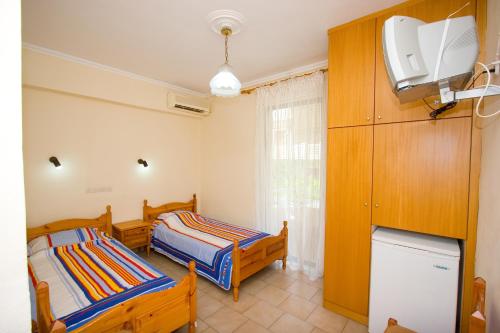 a room with two beds and a tv in it at Malamatenia Studios in Loutra Edipsou