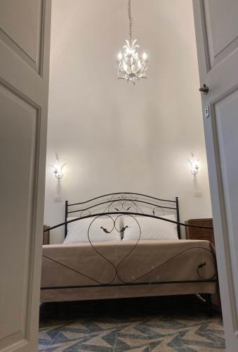 a bedroom with a bed with a chandelier at B&B Antica Dimora dell'Angelo in Nardò