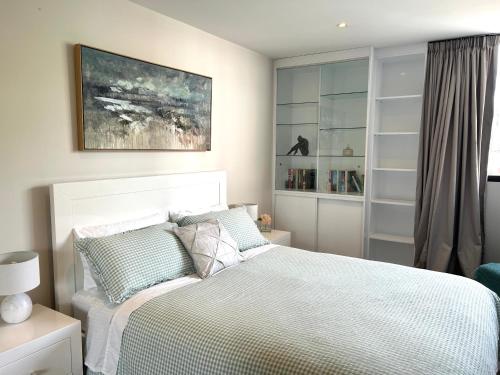 um quarto com uma cama branca e uma janela em Hobart Inner City Apartment em Hobart