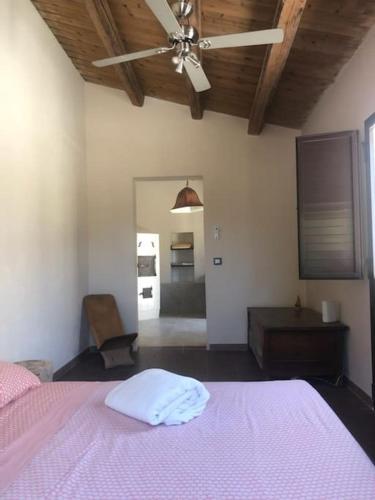 a bedroom with a pink bed with a pink blanket at oliveraie de caractère in Noto
