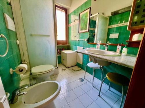 a green bathroom with two toilets and a sink at Casa Relax nel centro storico con posto auto in Vico Equense