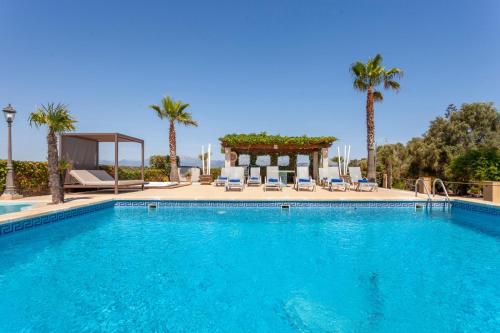 a swimming pool with palm trees and a gazebo at Can Ignasi in Can Picafort