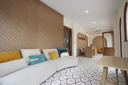 a living room with a white couch with colorful pillows at Casabella Homestay 102 Batam Penuin in Nagoya
