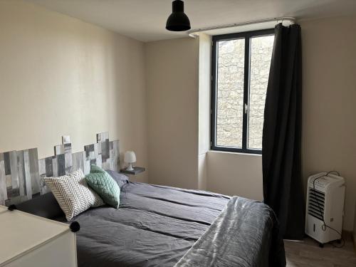 een slaapkamer met een bed en een raam bij Gites les Voyageurs in Vogüé