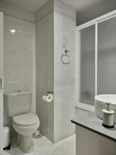 a white bathroom with a toilet and a sink at Suite Ribadesella VUT2191AS in Ribadesella