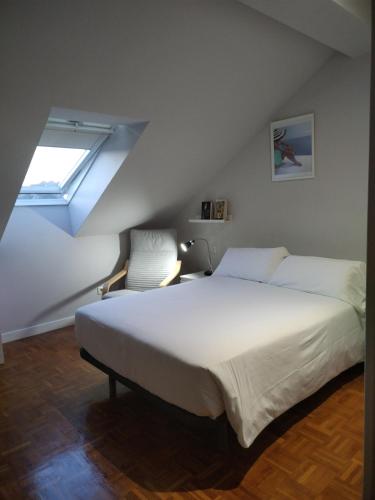 - une chambre avec un grand lit blanc et une chaise dans l'établissement Suite Ribadesella VUT2191AS, à Ribadesella