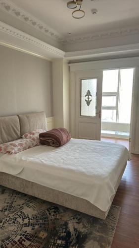 a bedroom with a large bed with a pillow on it at Luxury Apartment at Zaisan in Ulaanbaatar
