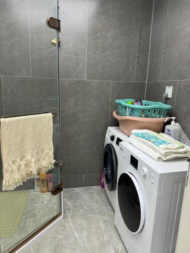 y baño con ducha y lavadora. en Luxury Apartment at Zaisan en Ulán Bator