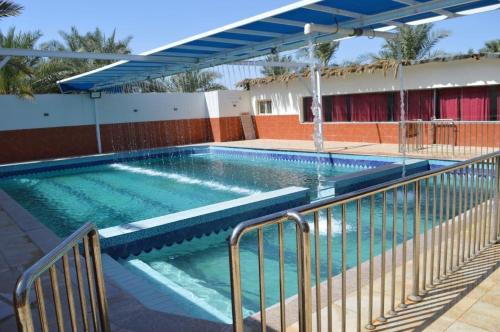 uma piscina com água azul num edifício em منتجع ريف خزيمة - الياسمين em Medina