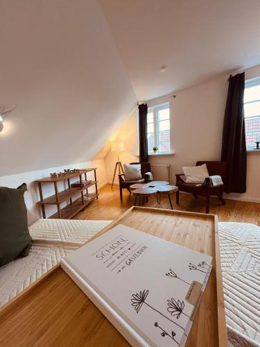 a room with a bed and a living room with a table at Lykkefund - Ferienwohnungen in Hafennähe in Glückstadt