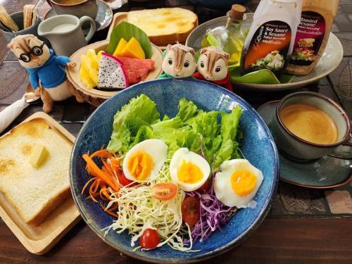 a plate of food with eggs and salad on a table at Wayside Guesthouse in Chiang Mai