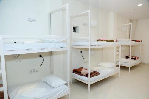 a room with white shelves with white beds at Charlie's Hostel By Purple India in New Delhi