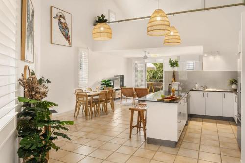 a kitchen and dining room with a table and chairs at Spacious Seaside Oasis on Dicky Beach in Caloundra