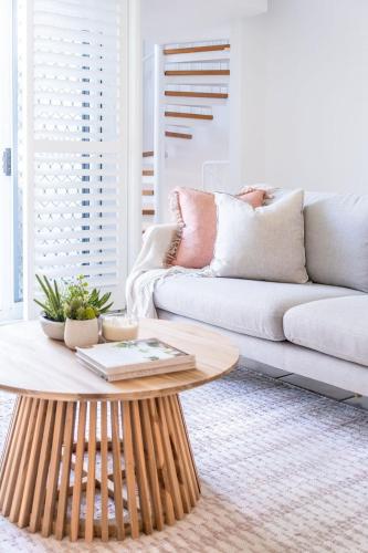 a living room with a couch and a coffee table at Spacious Seaside Oasis on Dicky Beach in Caloundra