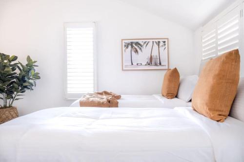 a white bedroom with a bed with white walls at Spacious Seaside Oasis on Dicky Beach in Caloundra