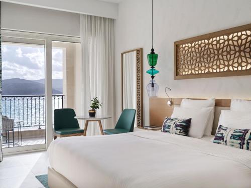 a hotel room with a bed and a balcony at The Chedi Luštica Bay in Tivat