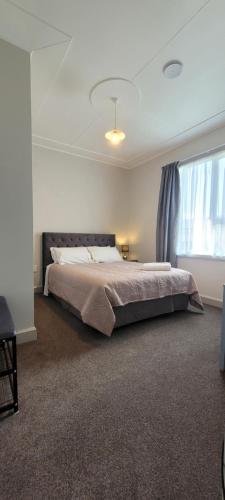 a bedroom with a large bed and a window at The Old Parsonage in Reefton