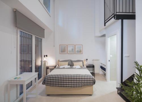 1 dormitorio con 1 cama en una habitación blanca en Apartamentos Bahía&Arena, en Santander