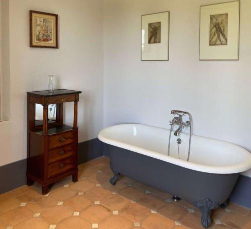 ein Badezimmer mit einer großen Badewanne und einem Holztisch in der Unterkunft Villa Cosmiana suites in Peccioli