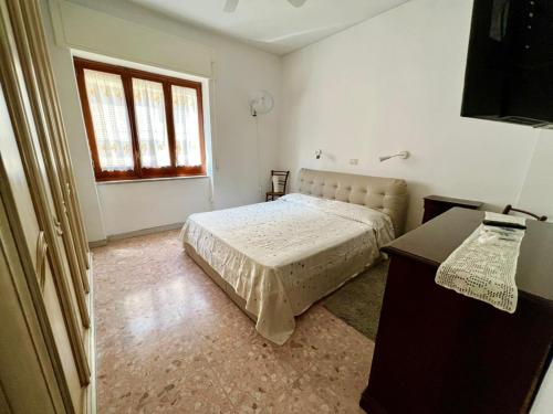a bedroom with a bed and a desk and a window at Casa Relax nel centro storico con posto auto in Vico Equense