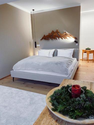 a bedroom with a bed with a plate of greens on a table at s'pölven NEST in Bad Häring