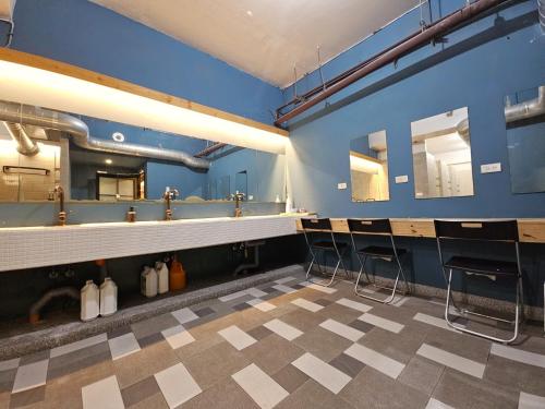 台北的住宿－寓見青旅，一间带椅子和蓝色墙壁的用餐室