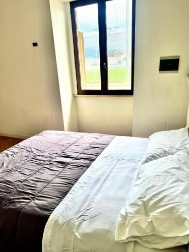 un letto bianco in una stanza con finestra di Pompei Gateway - Near Amalfi, Positano, Pompei, Napoli. a Scafati
