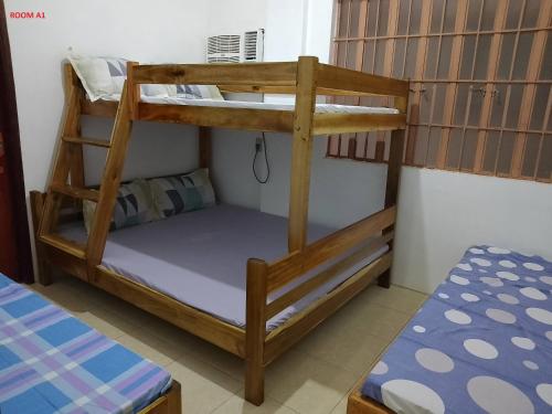 a bunk bed in a small room with a bunk bed gmaxwell gmaxwell gmaxwell at Estrelle Orange House - Backpackers Hub in Puerto Princesa City