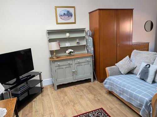a bedroom with a bed and a dresser with a television at Oldcotes Studio. in Firbeck