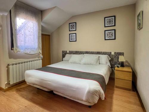 a bedroom with a large bed and a window at Hostal la Colmena in Avila