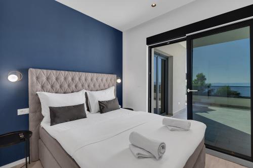 - une chambre avec un grand lit et une grande fenêtre dans l'établissement Villa Balmis House A, à Makarska