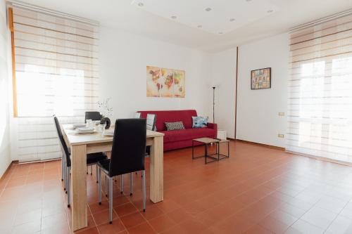 uma sala de estar com uma mesa e um sofá vermelho em APPARTAMENTO ACACIA em Imola