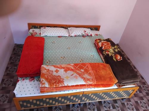 ein Bett mit bunten Decken und Kissen darauf in der Unterkunft Vigyan Guest house katagla kasol in Kasol