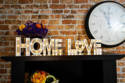 zegar na kominku z napisem, który czyta domową miłość w obiekcie Casa de oaspeti DaciAna w Braszowie